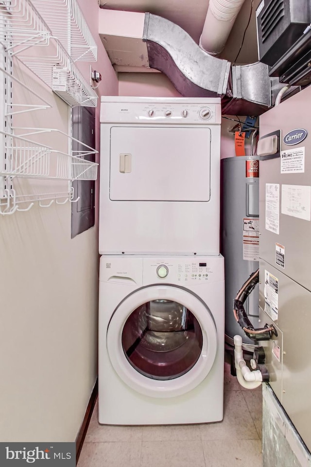 3101 New Mexico Ave NW Unit 847, Washington, DC 20016 - laundry area featuring electric water heater, tile patterned flooring, stacked washer / drying machine, baseboards, and laundry area