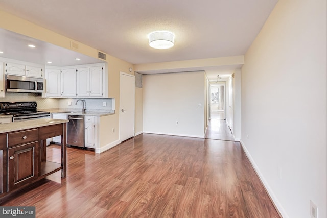 3101 New Mexico Ave NW Unit 847, Washington, DC 20016 - kitchen with visible vents, a sink, decorative backsplash, white cabinets, and appliances with stainless steel finishes