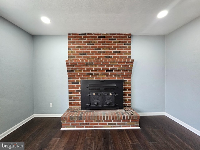 room details with a wood stove, recessed lighting, wood finished floors, and baseboards