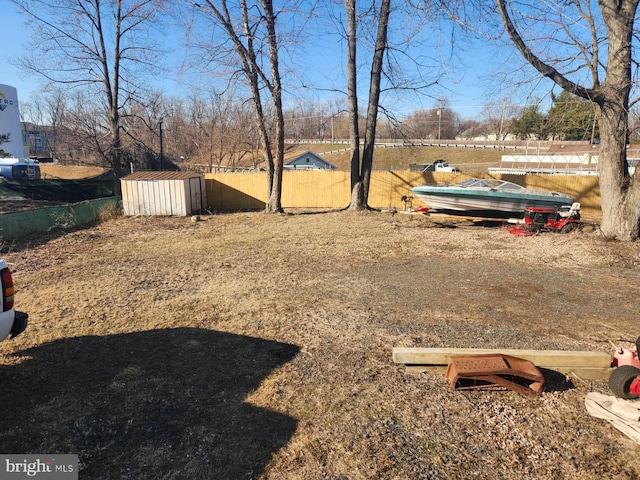 view of yard featuring an outdoor structure, fence, and a storage unit