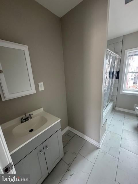 bathroom featuring marble finish floor, baseboards, shower / tub combo with curtain, and vanity