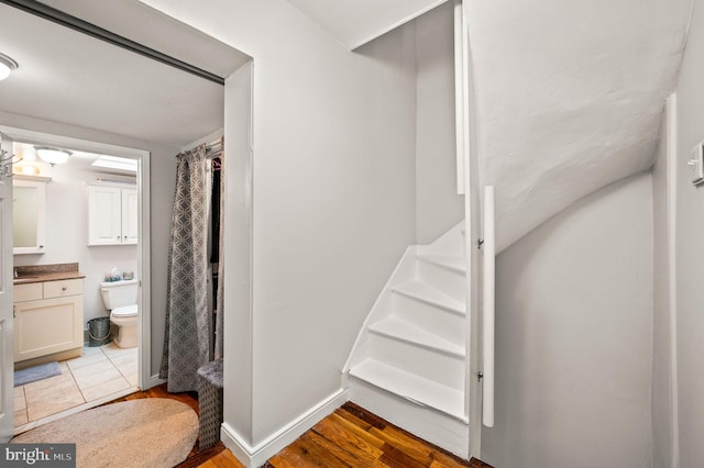 stairs featuring baseboards and wood finished floors