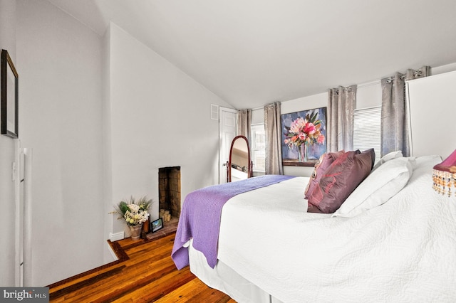 bedroom with vaulted ceiling and wood finished floors