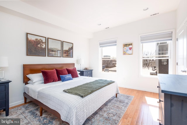 bedroom with light wood-type flooring, visible vents, baseboards, and recessed lighting