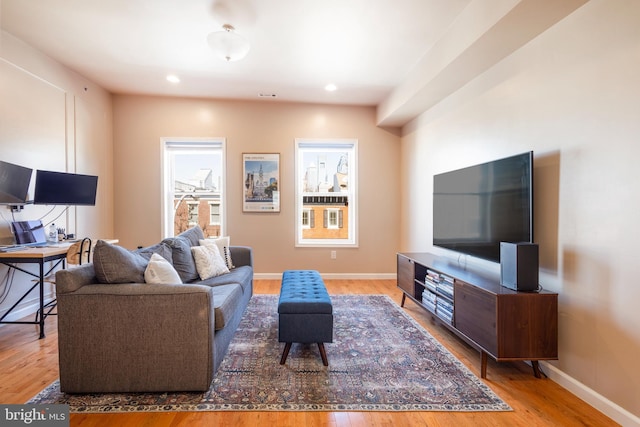 living area featuring baseboards, wood finished floors, and recessed lighting