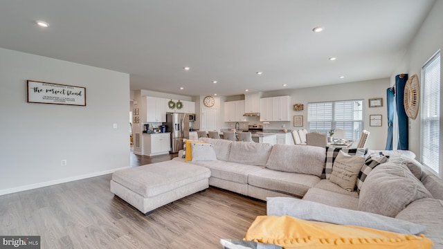 living room featuring recessed lighting, wood finished floors, and baseboards