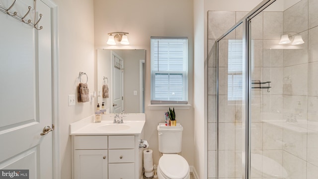 bathroom with a stall shower, vanity, and toilet