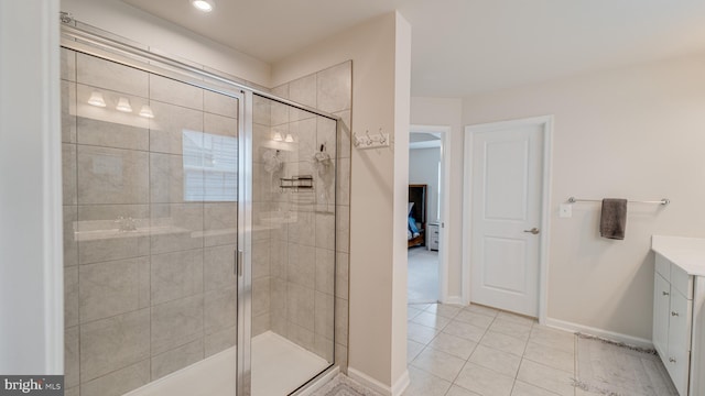 full bathroom with tile patterned flooring, baseboards, a shower stall, and vanity