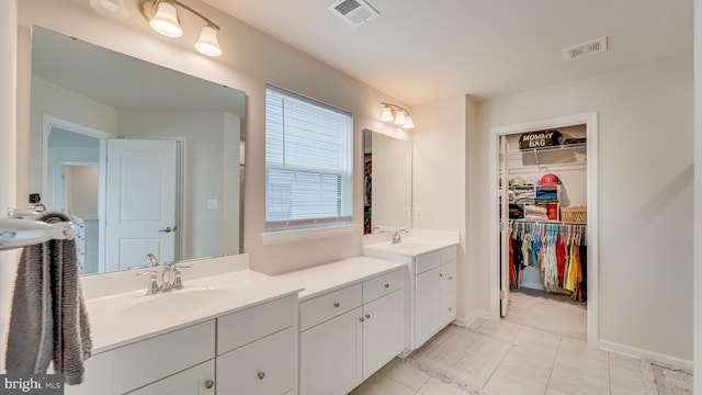 bathroom featuring tile patterned flooring, visible vents, vanity, and a spacious closet