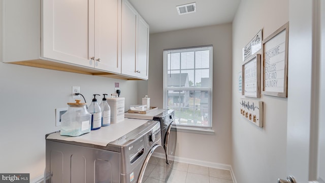 laundry room featuring a healthy amount of sunlight, cabinet space, visible vents, and washer and clothes dryer