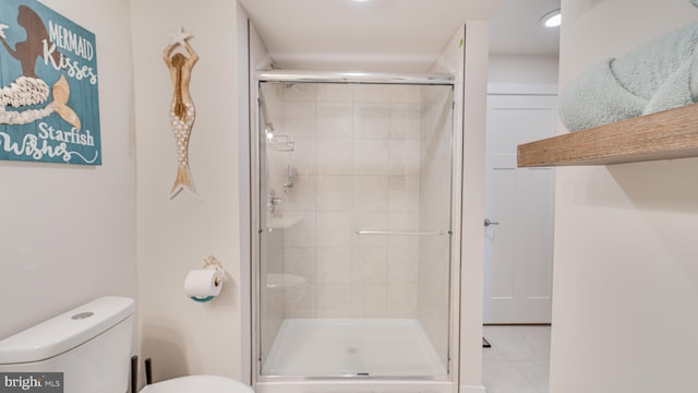 full bathroom with a stall shower, toilet, and tile patterned floors