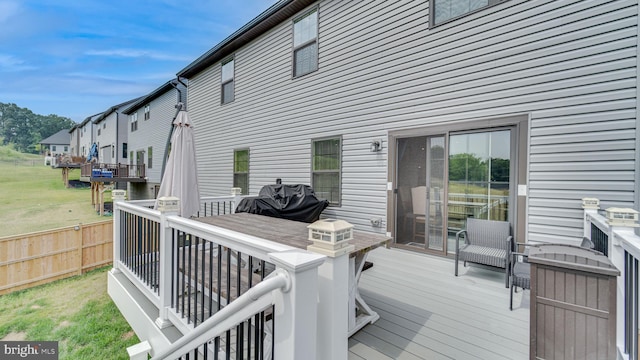 deck featuring grilling area, fence, and outdoor dining area