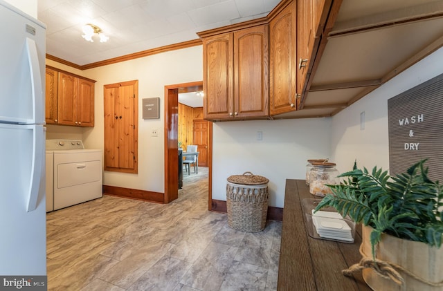 23 Swan St, Lambertville, NJ 08530 - kitchen featuring washer / dryer, baseboards, brown cabinetry, freestanding refrigerator, and crown molding