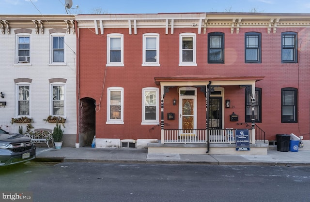 view of front of home with a porch and brick siding