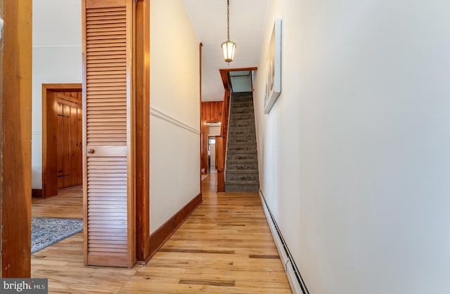 hallway with light wood finished floors, stairs, baseboards, and baseboard heating