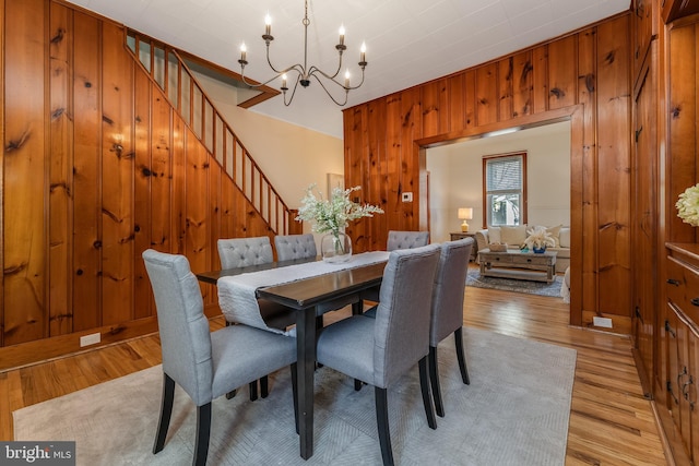 23 Swan St, Lambertville, NJ 08530 - dining space with wood walls, stairs, light wood finished floors, and a notable chandelier