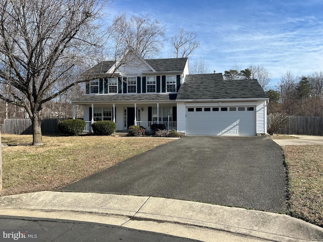 colonial inspired home featuring aphalt driveway, roof with shingles, a porch, an attached garage, and fence