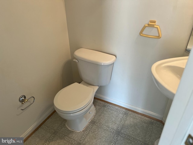 bathroom featuring toilet and baseboards