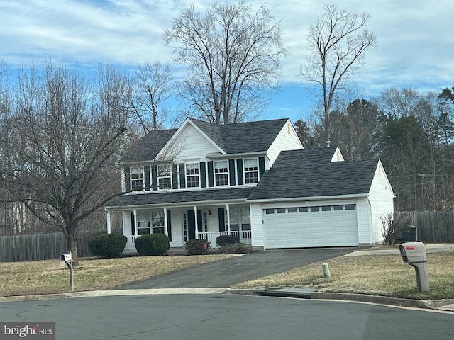 view of front of property with covered porch, fence, a garage, driveway, and a front lawn