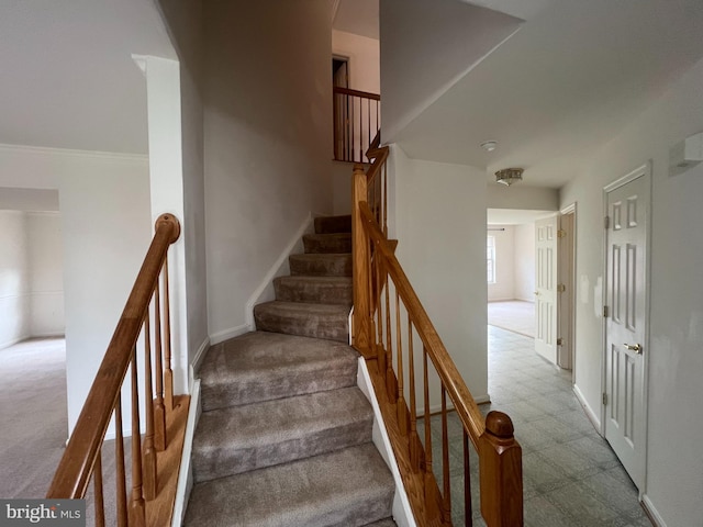 staircase featuring carpet floors, baseboards, and tile patterned floors