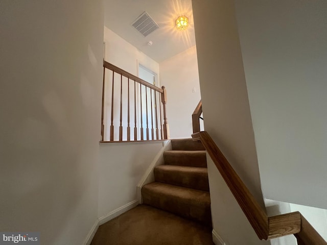 stairs with baseboards, visible vents, and carpet flooring