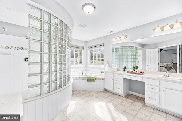 ensuite bathroom with visible vents, vanity, ensuite bath, a bath, and walk in shower