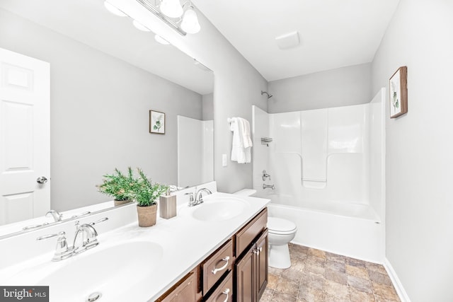 full bath with double vanity, bathtub / shower combination, a sink, and toilet