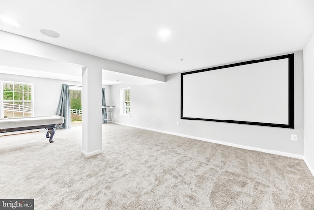 cinema room with carpet, a wealth of natural light, and baseboards