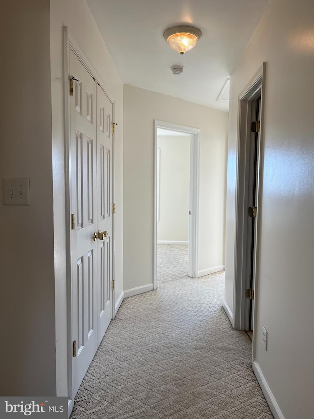 hallway featuring carpet floors and baseboards