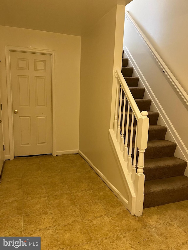 staircase featuring baseboards