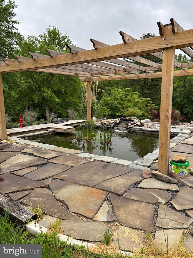 view of patio with a garden pond and a pergola