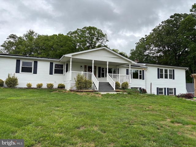 ranch-style house featuring covered porch and a front yard