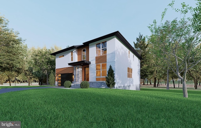 view of front of property featuring a front yard, driveway, and an attached garage