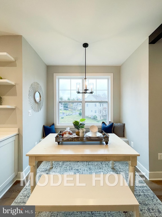 dining room featuring breakfast area, dark wood-style flooring, a notable chandelier, and baseboards