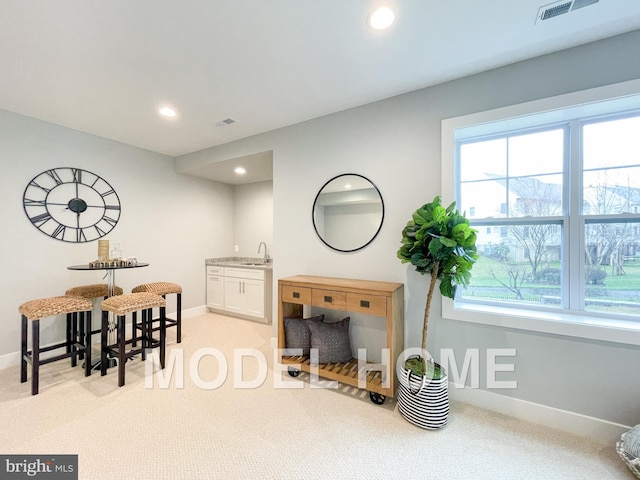 interior space featuring light colored carpet, recessed lighting, visible vents, and baseboards