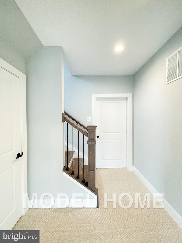 stairs with carpet floors, baseboards, and visible vents