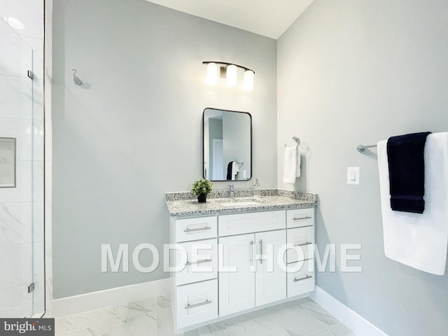 bathroom featuring marble finish floor, a shower stall, vanity, and baseboards