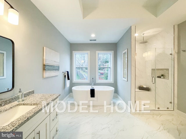 bathroom with marble finish floor, a shower stall, vanity, and a soaking tub