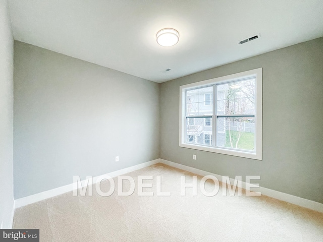 carpeted spare room with baseboards and visible vents