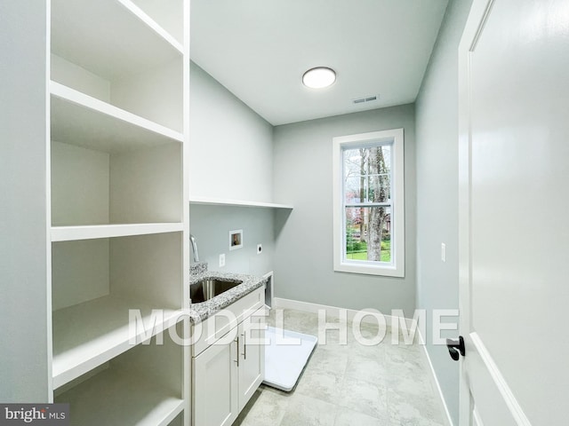 clothes washing area with cabinet space, visible vents, electric dryer hookup, washer hookup, and a sink