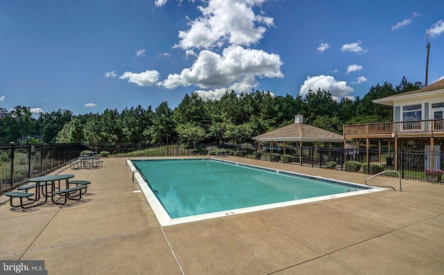 pool with a patio area, fence, and a gazebo