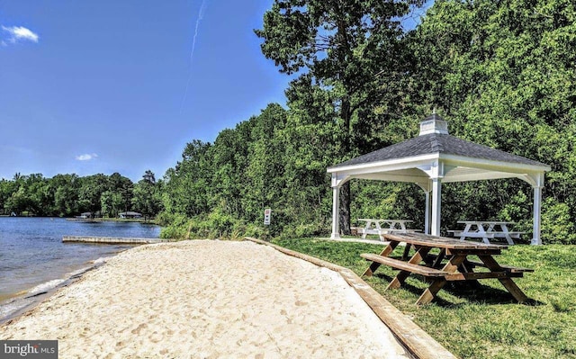 view of property's community featuring a water view, a wooded view, and a gazebo