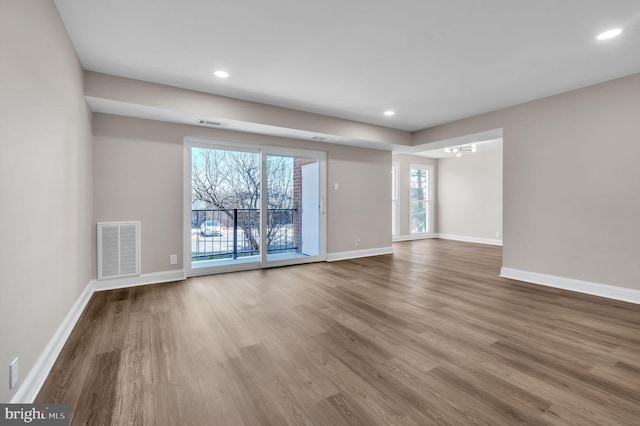 empty room with recessed lighting, visible vents, baseboards, and wood finished floors