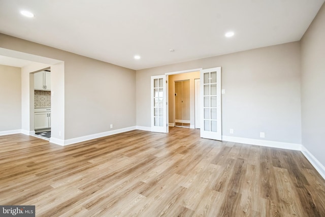 unfurnished bedroom featuring light wood-type flooring, recessed lighting, baseboards, and french doors