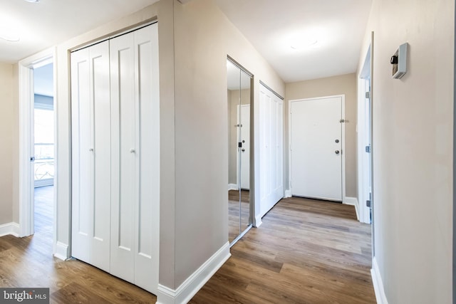 corridor featuring wood finished floors and baseboards