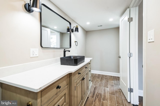 bathroom with recessed lighting, visible vents, wood tiled floor, vanity, and baseboards