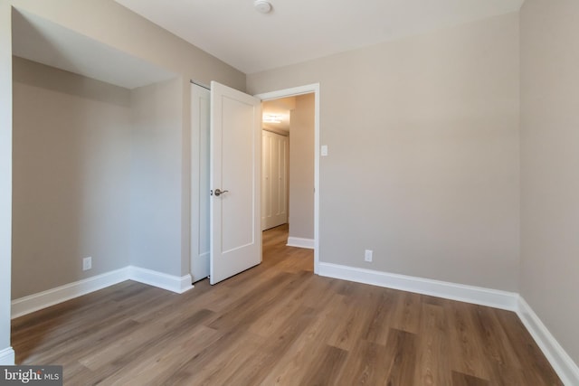 unfurnished bedroom featuring baseboards and wood finished floors