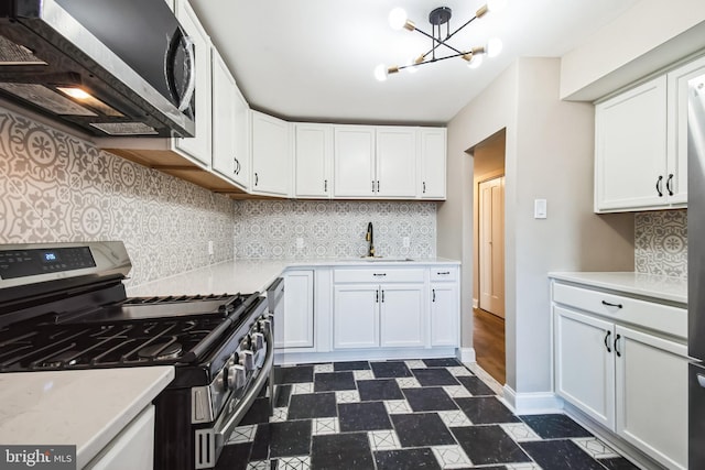 kitchen with white cabinetry, stainless steel appliances, a sink, and light countertops