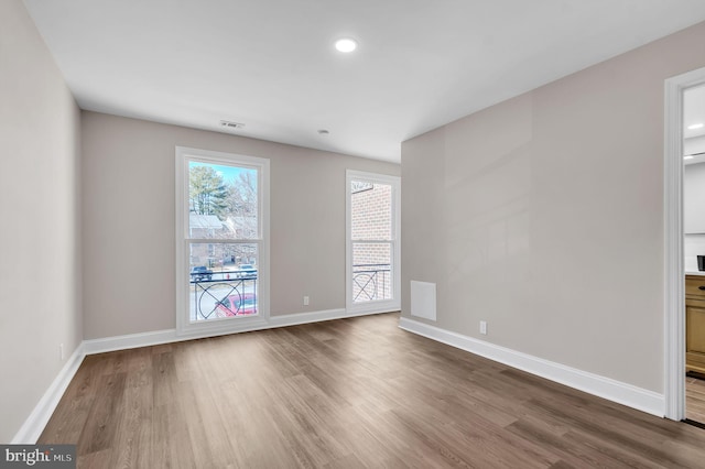 empty room featuring visible vents, baseboards, wood finished floors, and recessed lighting