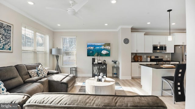 living room with recessed lighting, a ceiling fan, baseboards, light wood-style floors, and ornamental molding